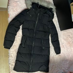 Black moose knuckles coat with a gray fur hood.